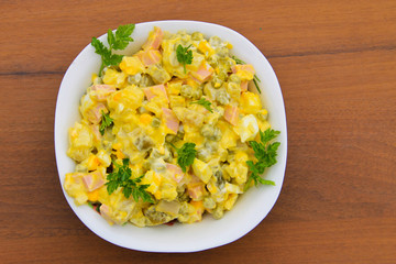 Russian traditional salad olivier on wooden table