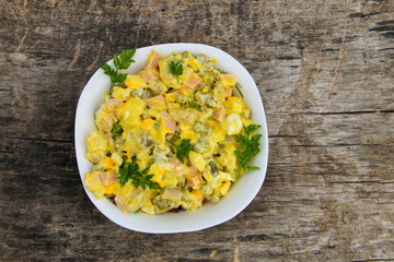 Russian traditional salad olivier on wooden table
