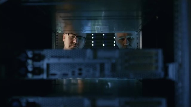 Two Server Engineers Install Hardware in Server Rack. They Work in Big Modern Data Center. Shot on RED EPIC-W 8K Helium Cinema Camera.