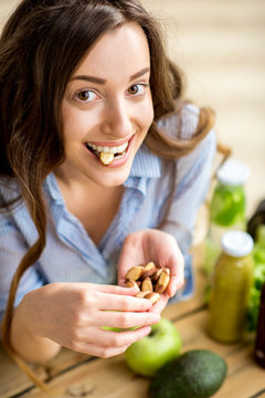 Closeup View From Above Of A Woman Eating Brasil Nuts With Healthy Food On The Background