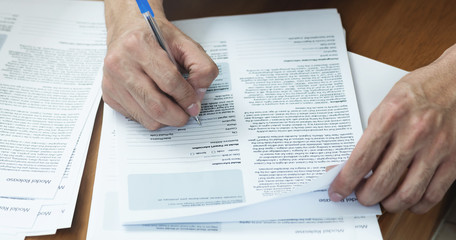 Naklejka premium Close up of Man hand with pen writing and signing on Model release document form.