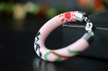 Pink bracelet with panda on a dark background