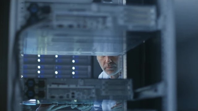  Two Server Technicians Install Hardware in Server Rack. They Work in Big Modern Data Center. Shot on RED EPIC-W 8K Helium Cinema Camera.