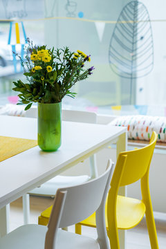 Decor With Yellow Flowers On The Table And Pictures On The Wall. Interior.
