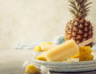 Retro style toned photo of homemade frozen pineapple juice popsicles. Summer food concept with copy...