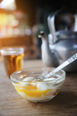 Local Thai morning food hot tea, soft boiled eggs on wood background