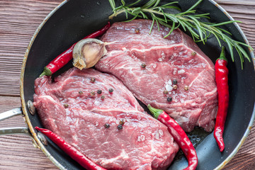 Steak on grill pan on wooden background