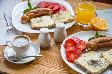 Breakfast with fried sausages, cheese toasts and coffee