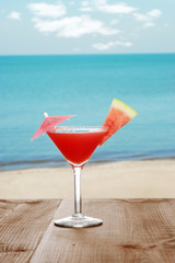 watermelon martini by the beach with fruit slice