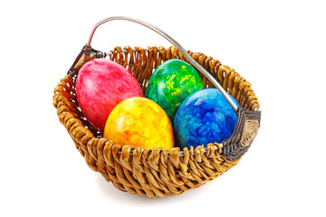 Easter eggs in a round basket on a white background