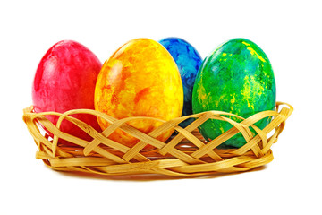 Easter eggs in wicker basket on a white background