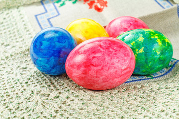 Painted colorful Easter eggs on a fabric tablecloth
