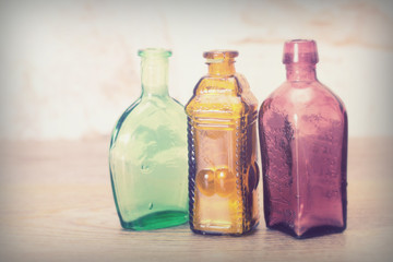 Coloured glass bottles on a rustic background