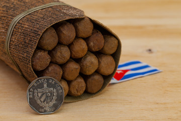 Luxury Cuban cigars and money on the wooden desk