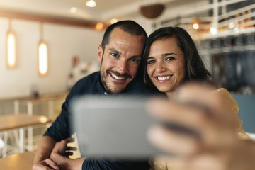 Happy couple taking selfie.