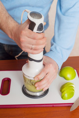 man prepares in a blender dessert, smoothies, apples