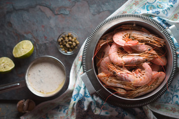 Big shrimps and savory sauce on the stone background top view