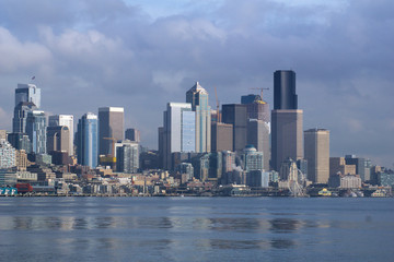 SEATTLE, WASHINGTON, USA - JAN 25th, 2017: A view on Seattle downtown from the waters of Puget Sound. Piers, skyscrapers and Ferris wheel in Seattle city before sunset