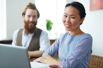 Team of creative designers sitting by workplace in studio