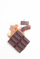 Chocolate pieces with nuts and berries on white