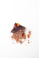 Chocolate pieces with nuts and berries on white