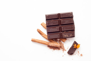 Chocolate and cinnamon sticks on white background