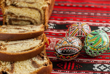     romanian traditional easter sponge cake and nicely decorated easter eggs 
