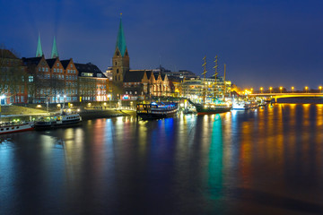 Embankment of the Weser River and Protestant Lutheran Saint Martin Church in the old town of Bremen, Germany. Night panoramic view.