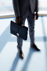 Briefcase in hand of businessman in elegant suit