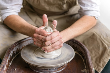 Hands working on pottery wheel