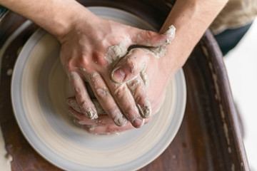 Hands working on pottery wheel