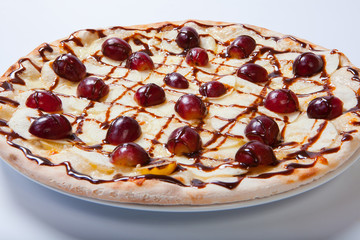sweet apple pizza with sliced grape on white background