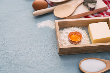Baking cake in rural kitchen - dough recipe ingredients (eggs, flour, milk, butter, sugar) on white wooden table from above.