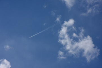 飛行機雲と青空「空想・雲のモンスターの前を飛ぶ航空機」成功など前向きのイメージ
