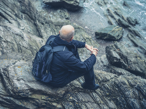 Senior man sitting on rocks