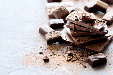 Pile of chocolate bars Milk and dark chocolate Chocolate candy Cocoa powder on background Horizontal photo Copy space