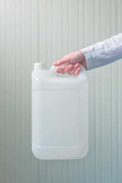 White plastic tank canister in female hand