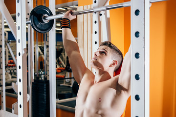 Handsome young man doing exercises in the gym. The concept of fitness, sports and a healthy lifestyle.