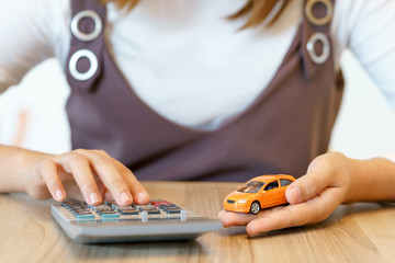 Woman calculating money with car insurance concept and calculator.