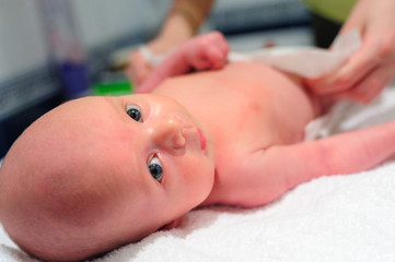 Mom puts a diaper on the baby
