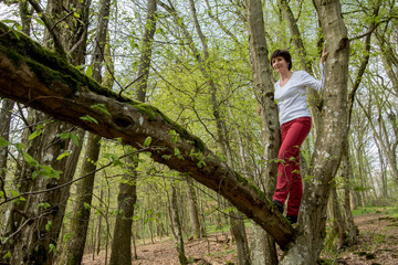 Naklejka na ściany i meble Frau balanciert über umgestürzten Baum Ruhe und Kraft in der Natur