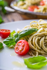 Spaghetti. Italian pasta spaghetti with basil pesto cherry tomatoes and olive oil.