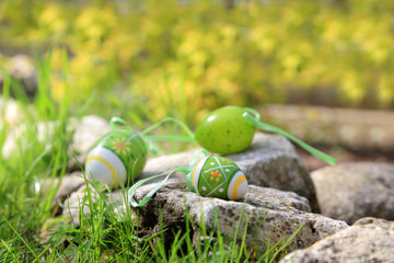 Kolorowe jajka na kamieniach na zewnątrz.