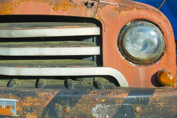 Front headlight of an old car. Rusty, abandoned.