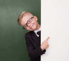 Boy in a business suit pointing at blank placard