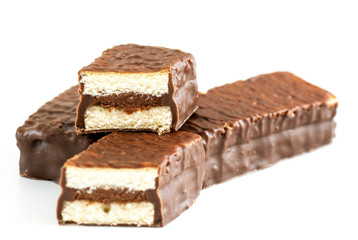 mini sponge cakes with cocoa cream and chocolate coating over white