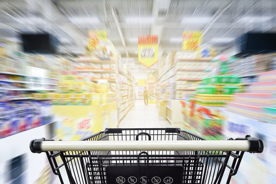 Supermarket aisle with empty black shopping cart