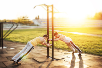 Two man stand at stadium with sunset background