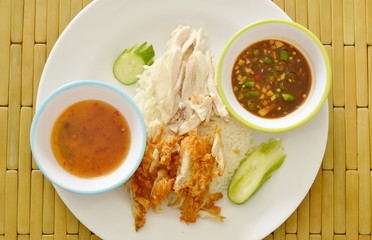 boiled and deep fried chicken on cooked rice with different dipping sauce on plate