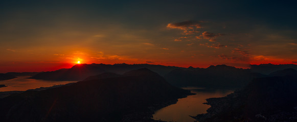 Sunset in Montenegro over the mountains and the sea. Orange sunsets.